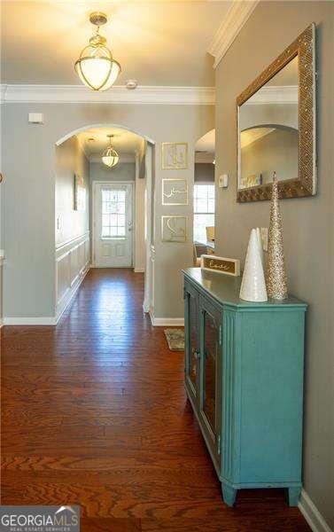 4271 Haywater Cv, Buford, GA 30519 - entrance foyer with arched walkways, crown molding, dark wood-style floors, and baseboards