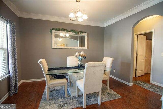 4271 Haywater Cv, Buford, GA 30519 - dining area featuring wood finished floors, crown molding, a chandelier, baseboards, and arched walkways