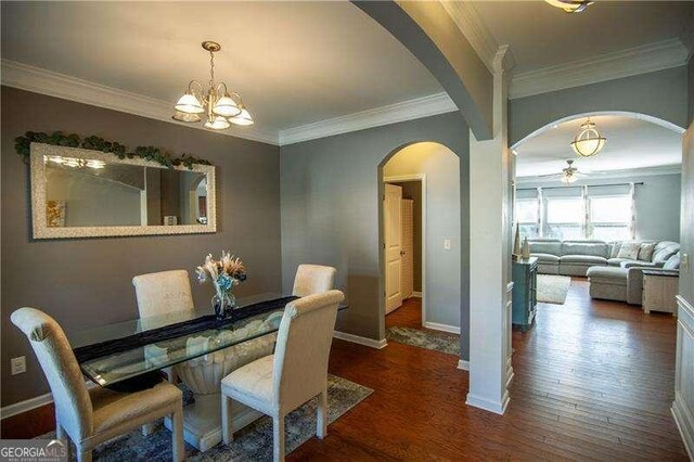 4271 Haywater Cv, Buford, GA 30519 - dining room with a chandelier, wood finished floors, crown molding, and plenty of natural light