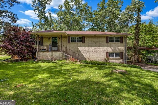 view of front of property with a carport, brick siding, and a front yard