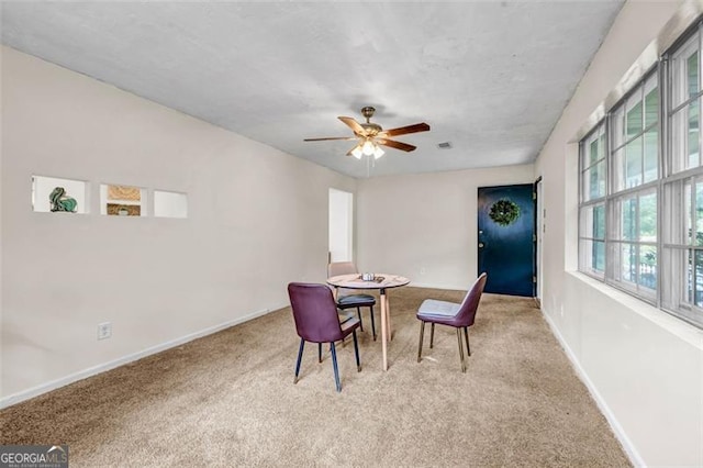 dining space with carpet, baseboards, and ceiling fan