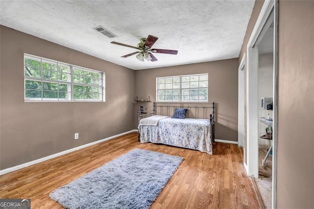 bedroom featuring wood finished floors, baseboards, and ceiling fan
