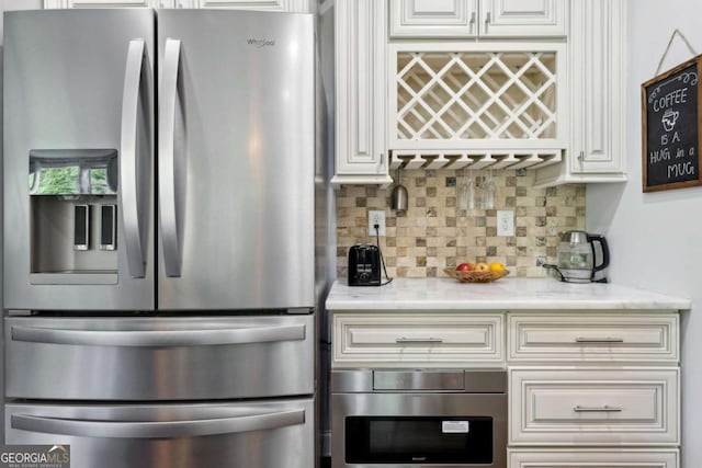 4630 Carriage Walk Ln, Cumming, GA 30040 - kitchen featuring stainless steel appliances, decorative backsplash, white cabinetry, and light stone countertops