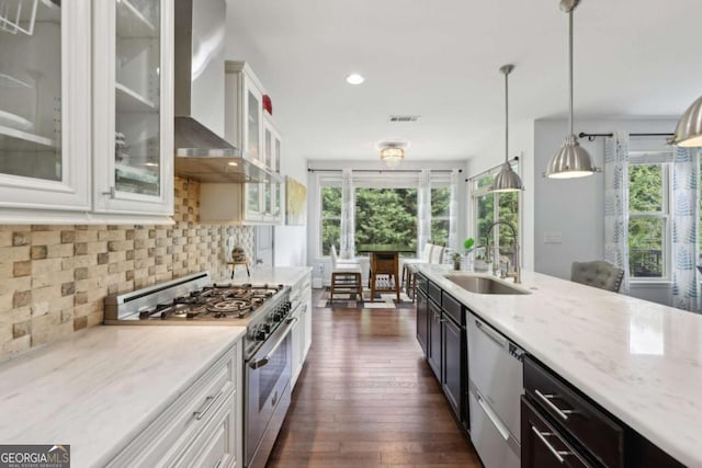 4630 Carriage Walk Ln, Cumming, GA 30040 - kitchen with appliances with stainless steel finishes, wall chimney exhaust hood, plenty of natural light, dark wood finished floors, and recessed lighting
