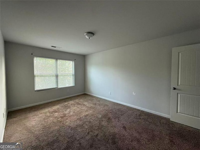 unfurnished room featuring carpet and baseboards