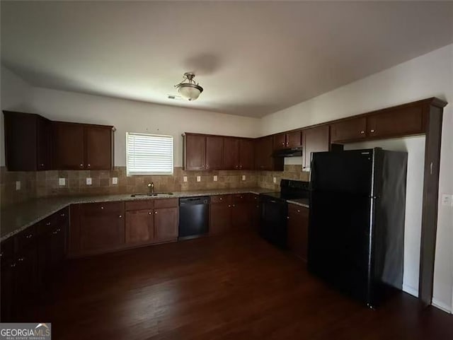 kitchen featuring black appliances, a sink, backsplash, and dark wood finished floors