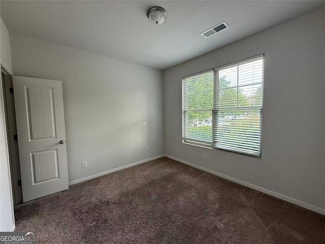 carpeted empty room featuring baseboards