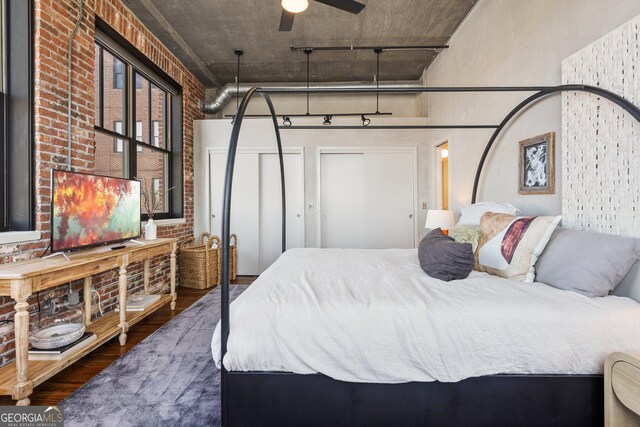 3235 Roswell Rd NE Unit 617, Atlanta, GA 30305 - bedroom featuring wood finished floors, brick wall, and rail lighting