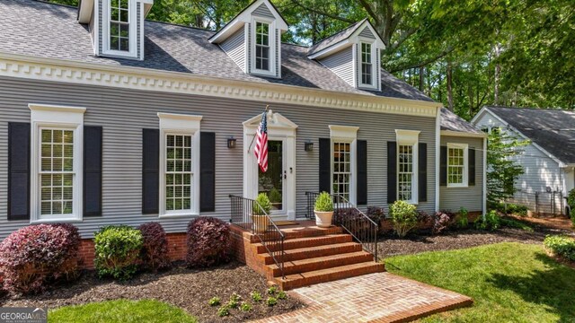 cape cod home with a shingled roof