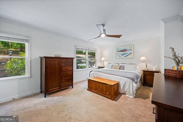 bedroom featuring crown molding, baseboards, a ceiling fan, and light carpet