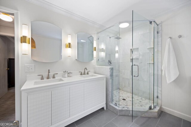 full bath featuring ornamental molding, a shower stall, tile patterned flooring, double vanity, and baseboards