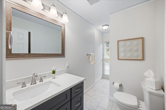 bathroom with marble look tile flooring, toilet, vanity, and baseboards