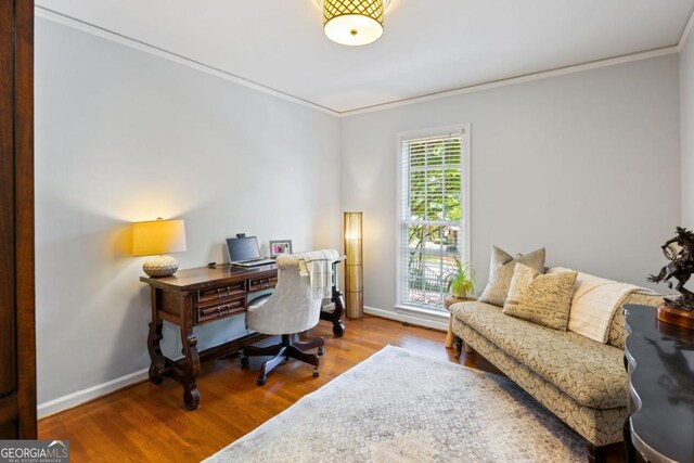 office area with crown molding, wood finished floors, and baseboards