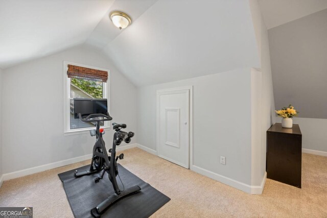 exercise area with vaulted ceiling, carpet, and baseboards