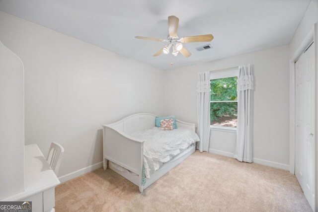 carpeted bedroom with baseboards, a closet, and a ceiling fan
