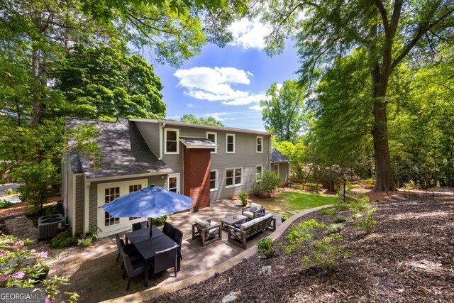 back of house with outdoor lounge area, a patio area, and central AC