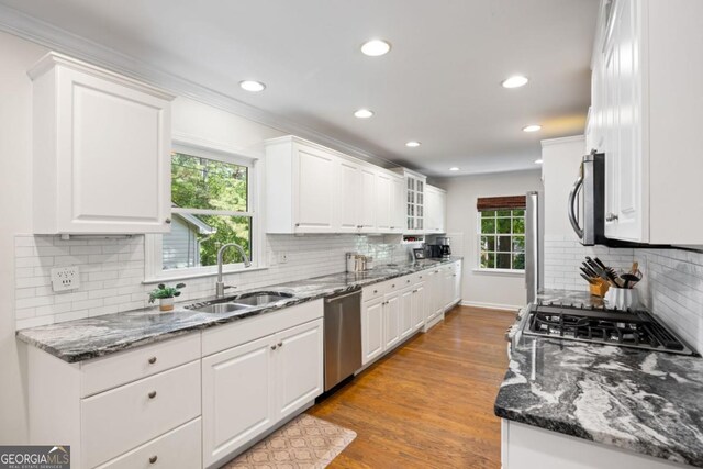 kitchen with a sink, appliances with stainless steel finishes, recessed lighting, tasteful backsplash, and white cabinets