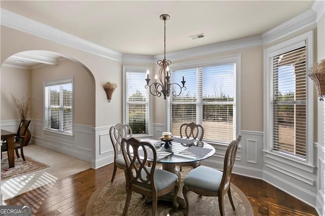 1307 Clarecastle Ln, Buford, GA 30519 - dining room featuring arched walkways, a chandelier, wainscoting, wood-type flooring, and ornamental molding