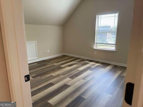 1307 Clarecastle Ln, Buford, GA 30519 - additional living space featuring vaulted ceiling, wood finished floors, and baseboards