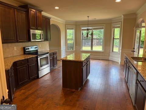 1307 Clarecastle Ln, Buford, GA 30519 - sitting room with healthy amount of natural light, wood finished floors, stairs, ornamental molding, and a ceiling fan