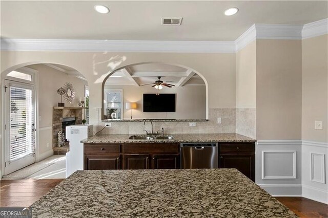 1307 Clarecastle Ln, Buford, GA 30519 - kitchen featuring stainless steel dishwasher, a sink, dark brown cabinetry, ceiling fan, and light stone counters