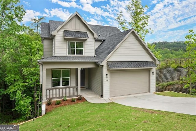 view of front of home featuring driveway, covered porch, a garage, a shingled roof, and a front lawn