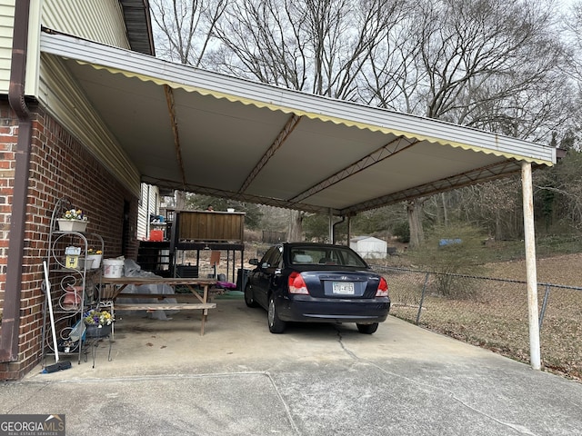view of parking featuring fence and an attached carport