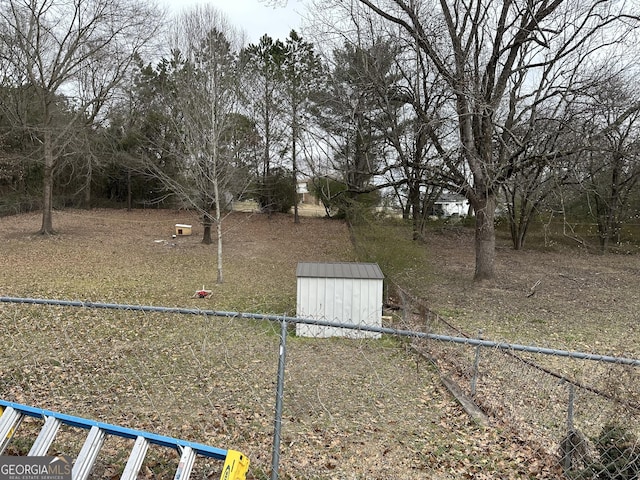 view of yard with a storage unit, an outdoor structure, and fence