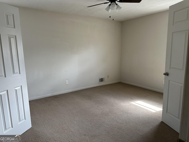 carpeted empty room with a ceiling fan and baseboards