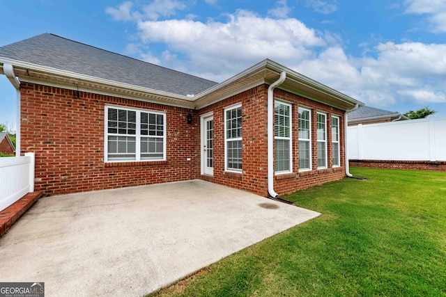 back of property featuring a patio, brick siding, and a shingled roof
