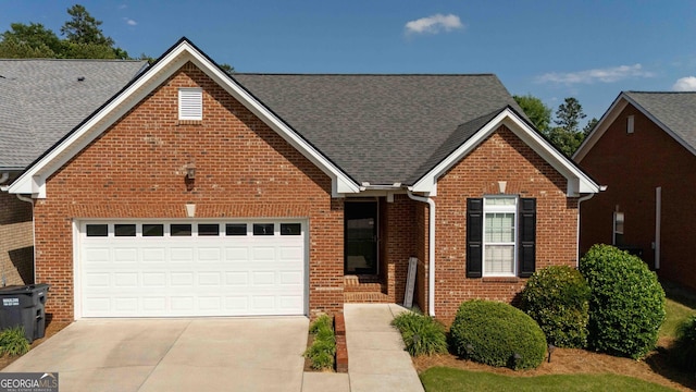 traditional-style house featuring brick siding, driveway, a garage, and a shingled roof