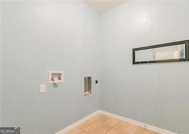 clothes washing area with electric dryer hookup, hookup for a washing machine, light tile patterned flooring, and baseboards