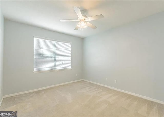 unfurnished room with baseboards, light carpet, and a ceiling fan