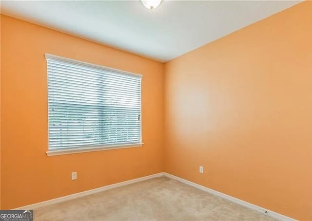 carpeted spare room featuring baseboards