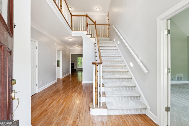 936 Bramble Oak Ct, Powder Springs, GA 30127 - stairs with hardwood / wood-style flooring, crown molding, baseboards, and a towering ceiling