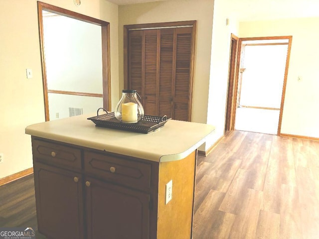 305 Glenloch Ln, Stockbridge, GA 30281 - kitchen featuring baseboards, wood finished floors, light countertops, and a kitchen island