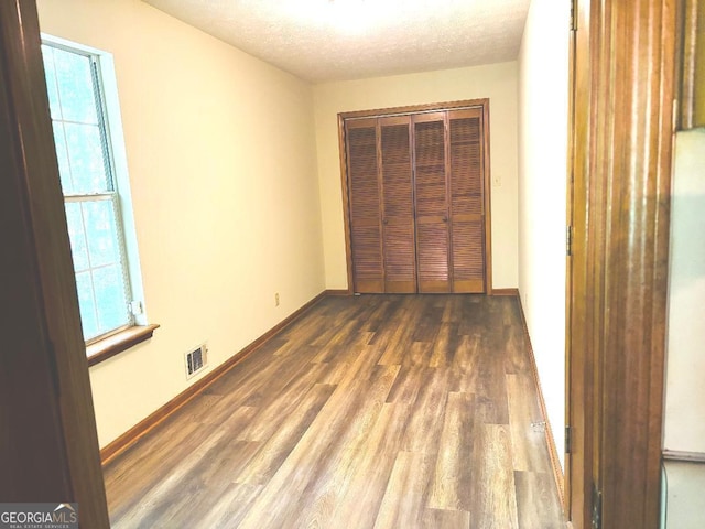 305 Glenloch Ln, Stockbridge, GA 30281 - unfurnished bedroom featuring wood finished floors, a closet, a textured ceiling, and baseboards