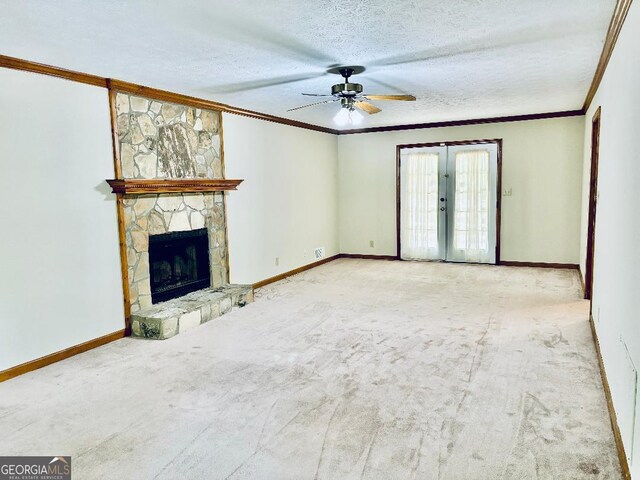 305 Glenloch Ln, Stockbridge, GA 30281 - unfurnished living room featuring crown molding, ceiling fan, carpet, a stone fireplace, and a textured ceiling