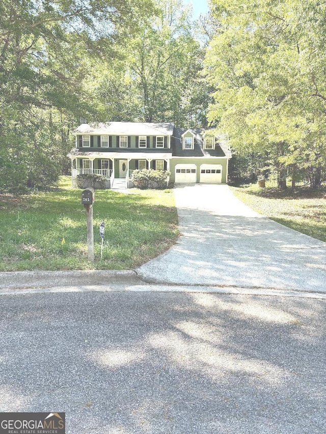 305 Glenloch Ln, Stockbridge, GA 30281 - view of front of property featuring driveway, a front yard, a garage, covered porch, and view of wooded area