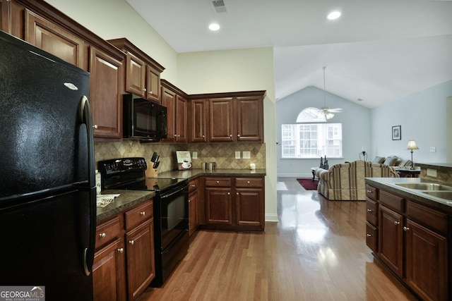2595 Grapevine Cir, Cumming, GA 30041 - kitchen featuring black appliances, dark countertops, light wood-style flooring, lofted ceiling, and ceiling fan
