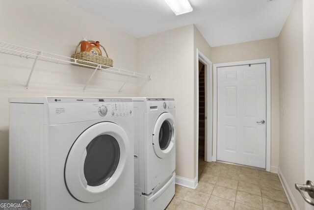 2595 Grapevine Cir, Cumming, GA 30041 - clothes washing area featuring washer and clothes dryer, baseboards, and light tile patterned floors
