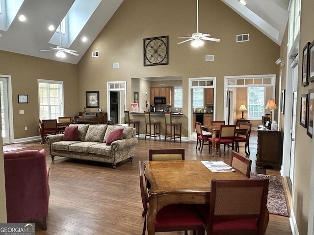 2595 Grapevine Cir, Cumming, GA 30041 - dining area featuring a ceiling fan, high vaulted ceiling, a skylight, wood finished floors, and plenty of natural light