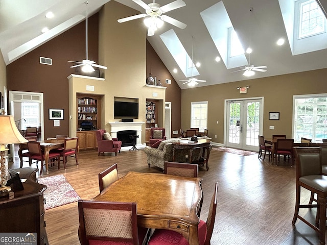 2595 Grapevine Cir, Cumming, GA 30041 - dining area featuring high vaulted ceiling, ceiling fan, a skylight, a fireplace, and wood finished floors