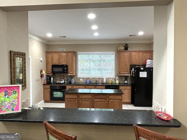 2595 Grapevine Cir, Cumming, GA 30041 - kitchen with black appliances, ornamental molding, decorative backsplash, a peninsula, and brown cabinets