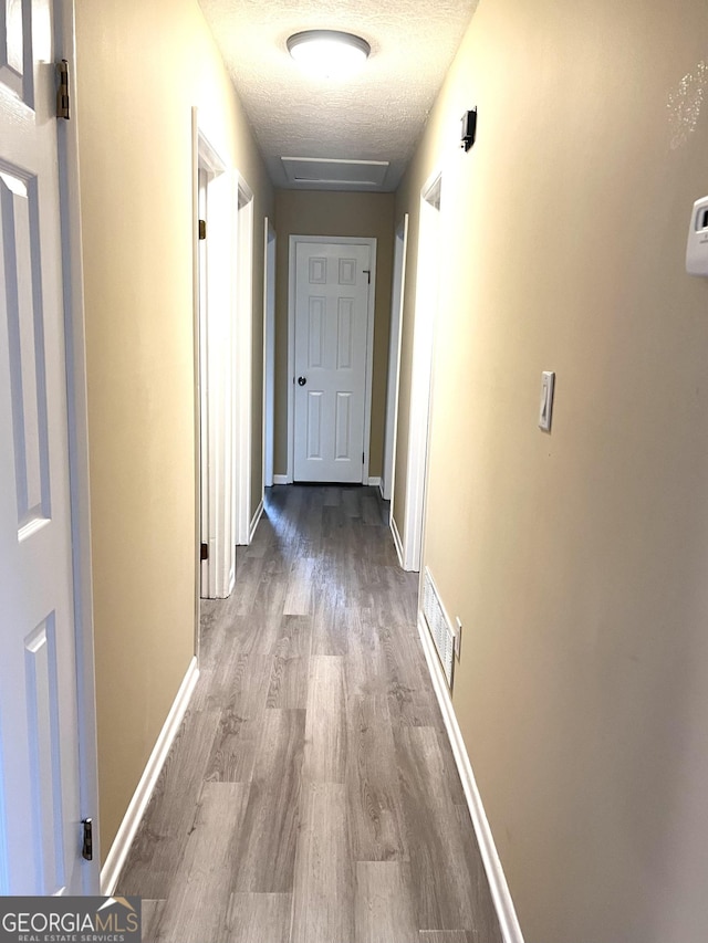 unfurnished room featuring a ceiling fan, a textured ceiling, dark wood-style flooring, and baseboards