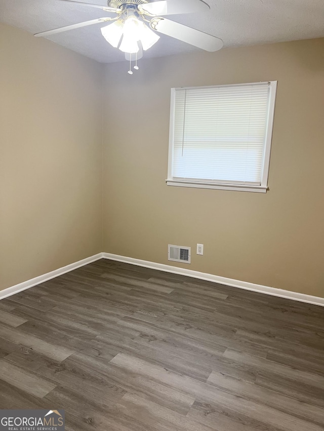 empty room featuring wood finished floors, baseboards, and a ceiling fan