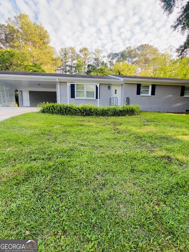 view of front of home with brick siding, a front lawn, an attached carport, and concrete driveway