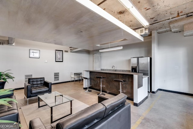 890 Memorial Dr SE Unit 105, Atlanta, GA 30316 - living area with wet bar, finished concrete flooring, and baseboards