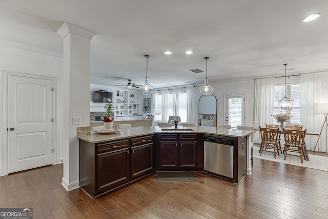 kitchen with stainless steel dishwasher, a sink, dark brown cabinetry, ceiling fan, and light stone counters