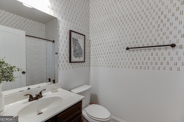 full bath featuring wallpapered walls, vanity, toilet, and a shower